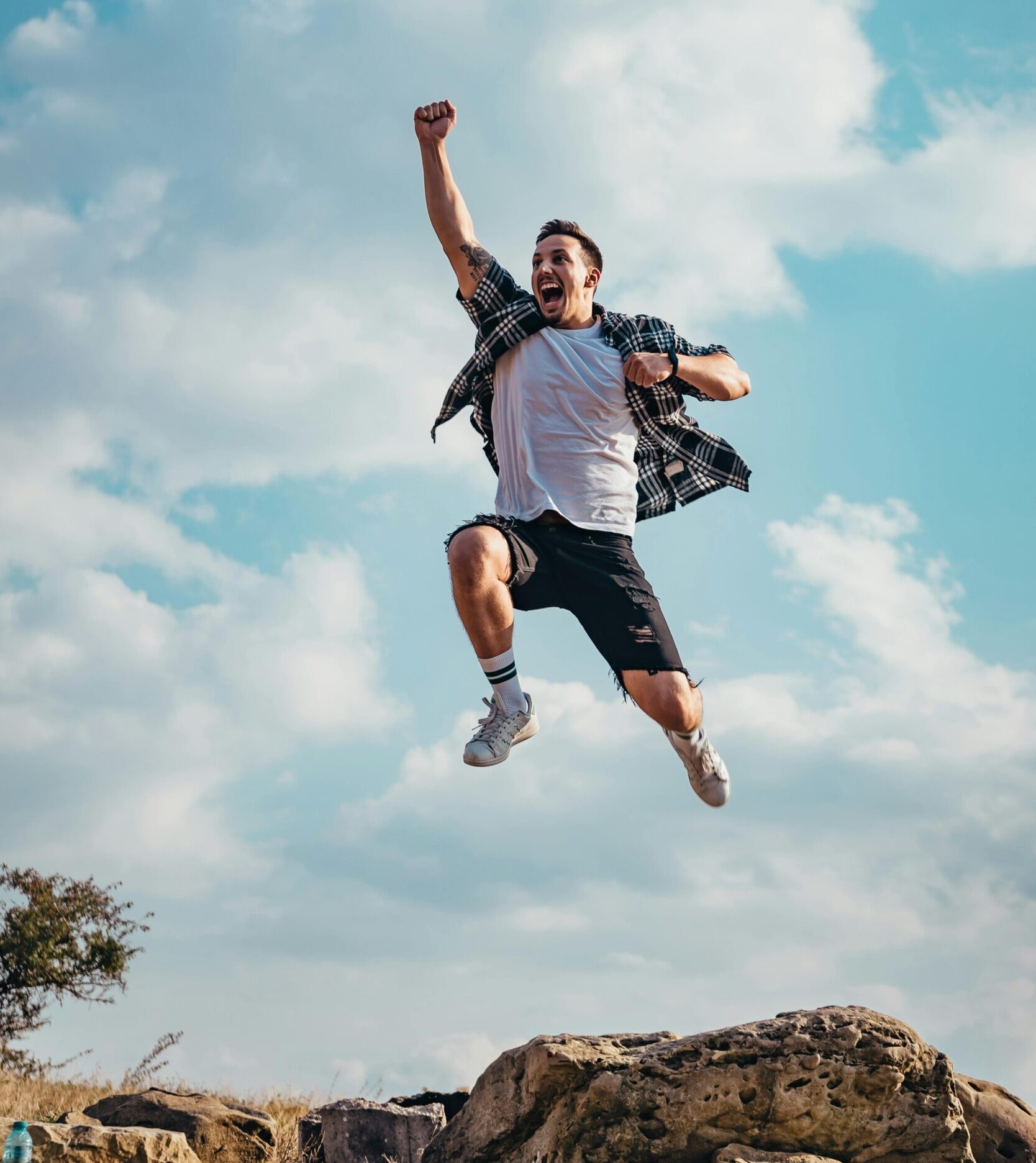 A vibrant image of a young man jumping with joy outdoors, capturing a moment of freedom and exhilaration.